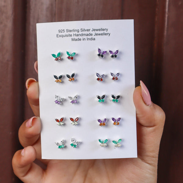 A closeup image of 10 pairs of Butterfly Gemstone Stud Earrings -1 by Carat For You on a brown background 