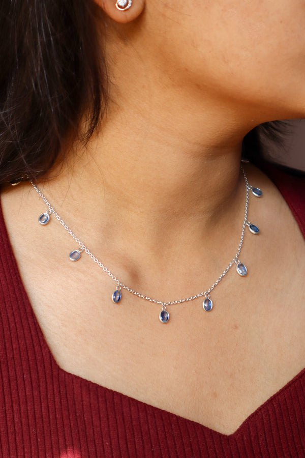 A closeup image of a girl wearing Classic Kyanite Charm Necklace by Carat For You 