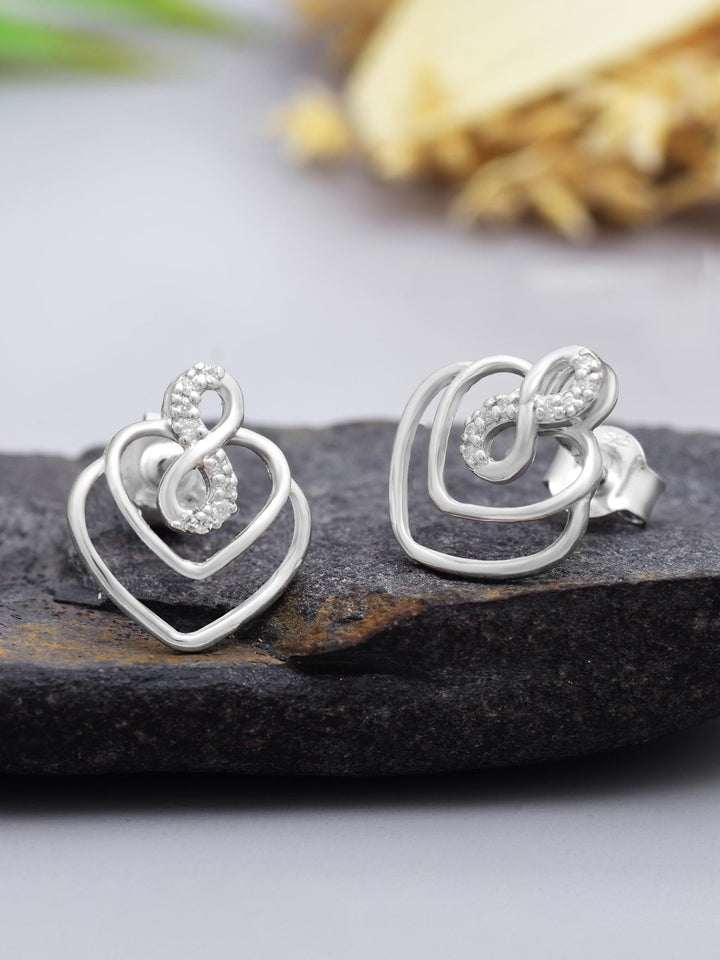 Infinity Heart Moissanite Stud Earrings by Carat For You on black rock