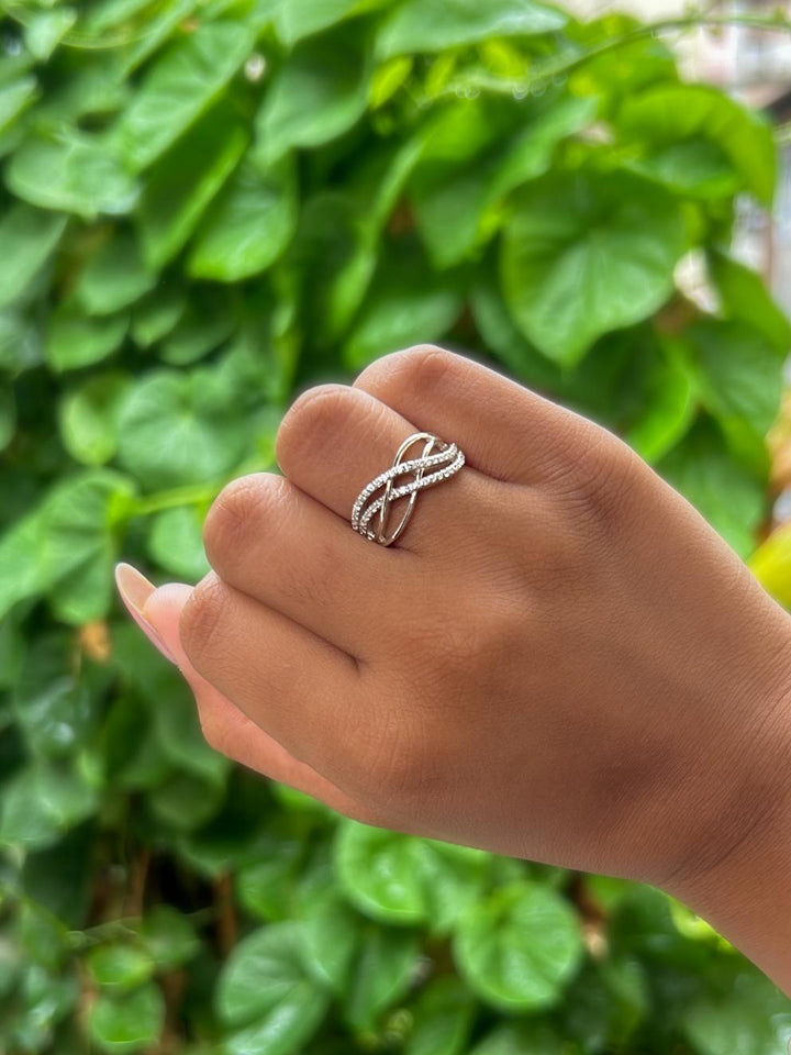 Model wearing Interwoven Moissanite Statement Ring by Carat For You on natural green leaves background