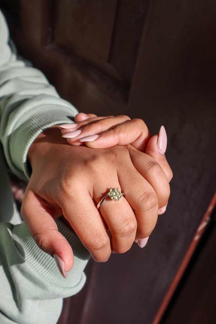Model in green sweater wearing Floral Peridot Flower Ring in 925 Sterling Silver