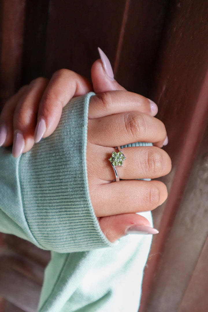 Model in green sweater wearing Floral Peridot Flower Ring in 925 Sterling Silver by Carat For You