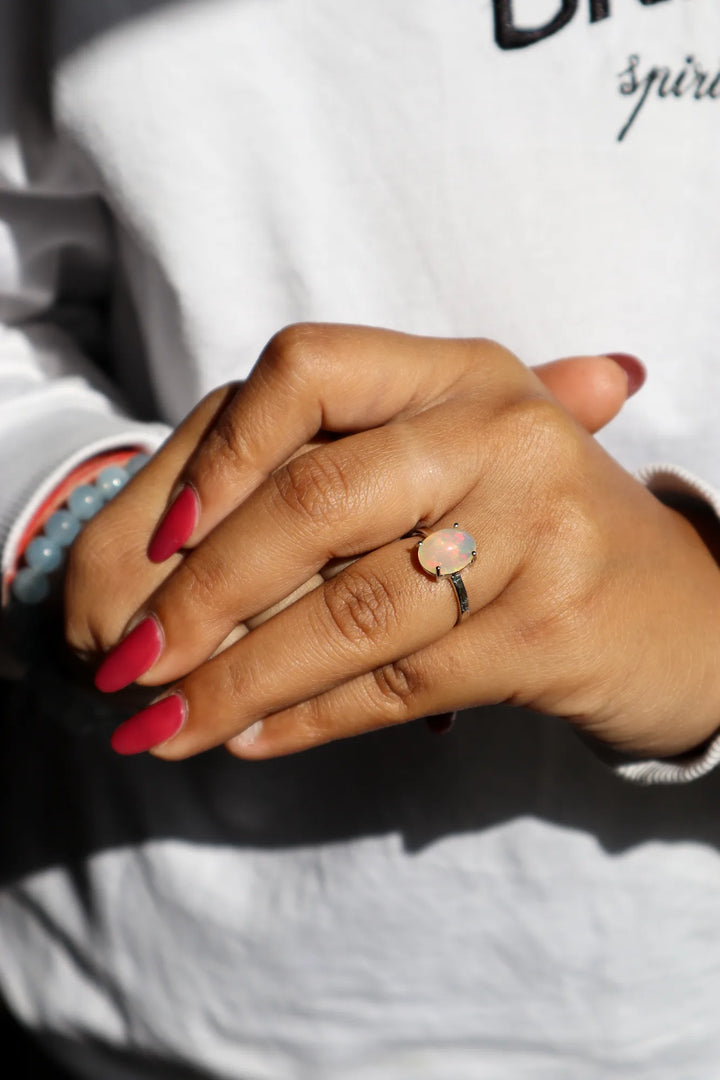 Model in white sweater wearing Natural Oval Opal Solitaire Ring in 925 Sterling Silver by Carat For You