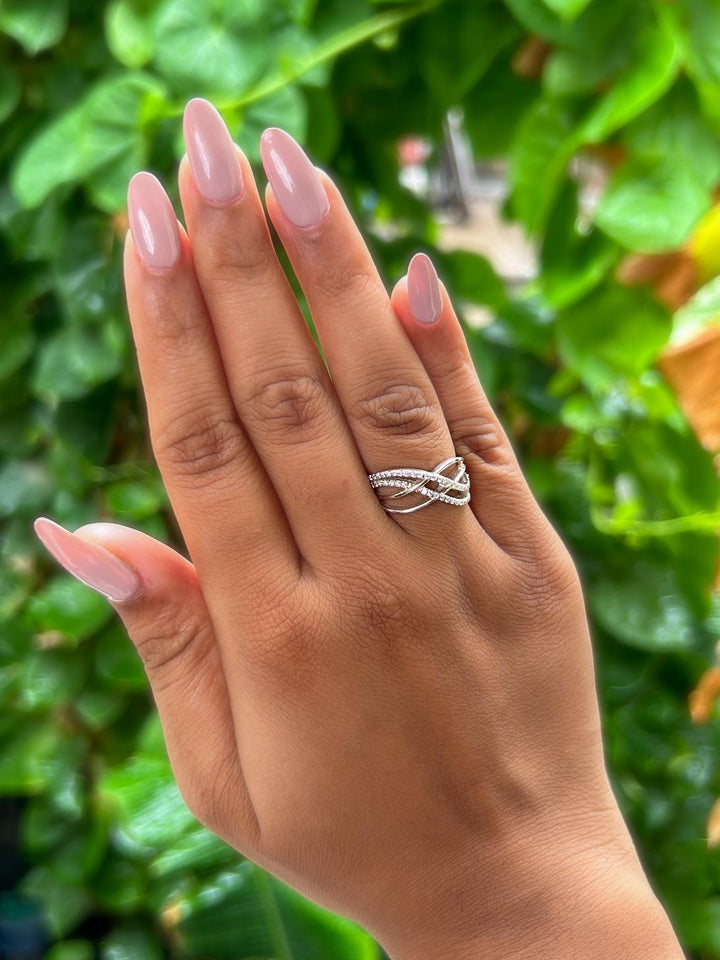 Model wearing Interwoven Moissanite Statement Ring by Carat For You on natural green leaves background