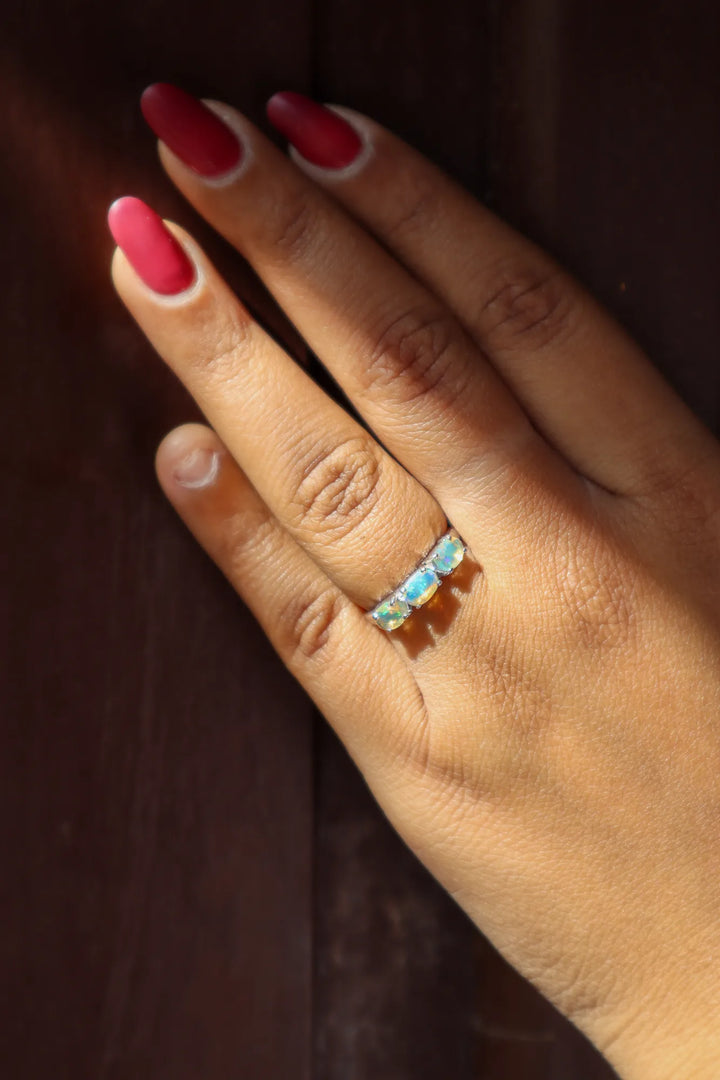 Hand with a Opal ring on a dark background