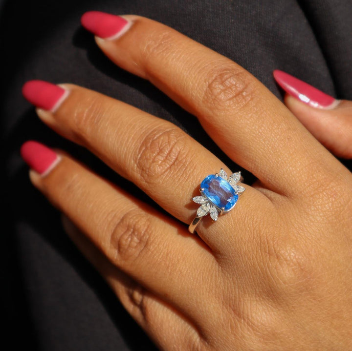 A model's hand displaying a sky blue kyanite gemstone ring with rhodium plating on a 925 Sterling Silver Band by Carat For You