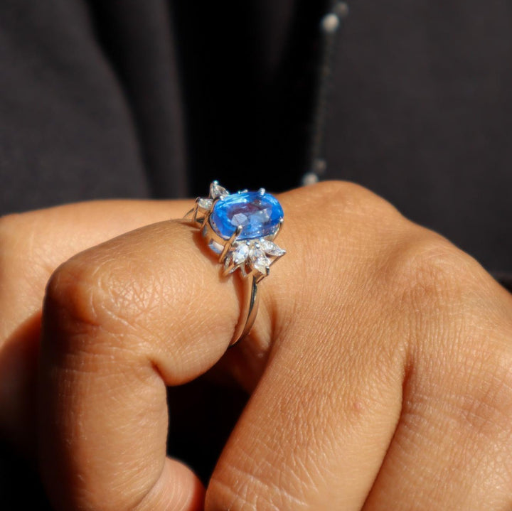A model's hand displaying a sky blue kyanite gemstone ring with rhodium plating on a 925 Sterling Silver Band by Carat For You