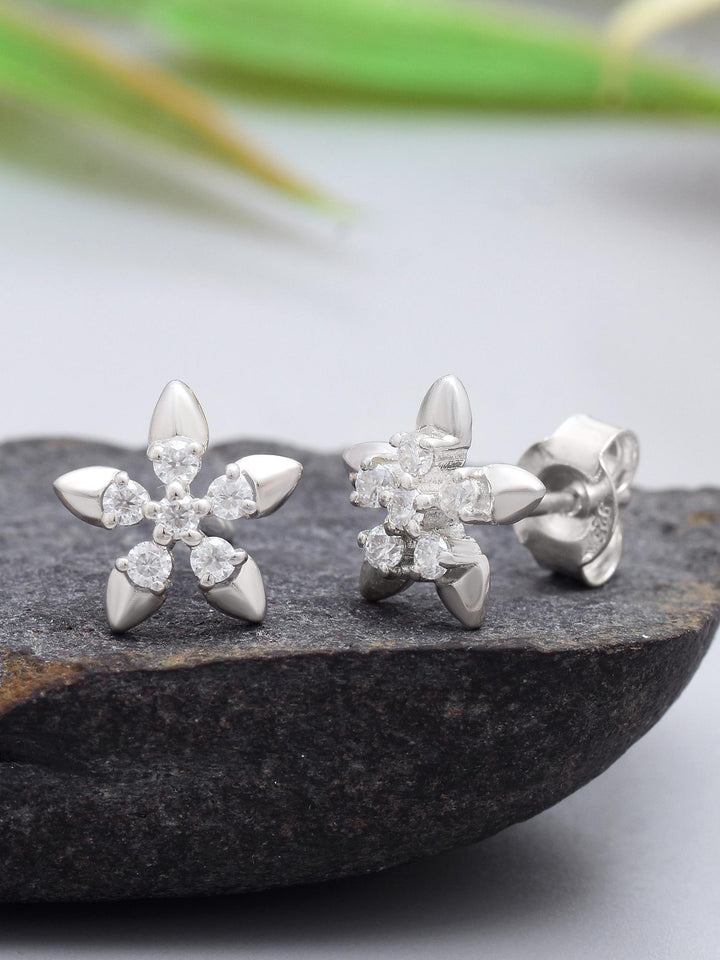 Timeless Flora Moissanite Stud Earrings on black rock and creative background